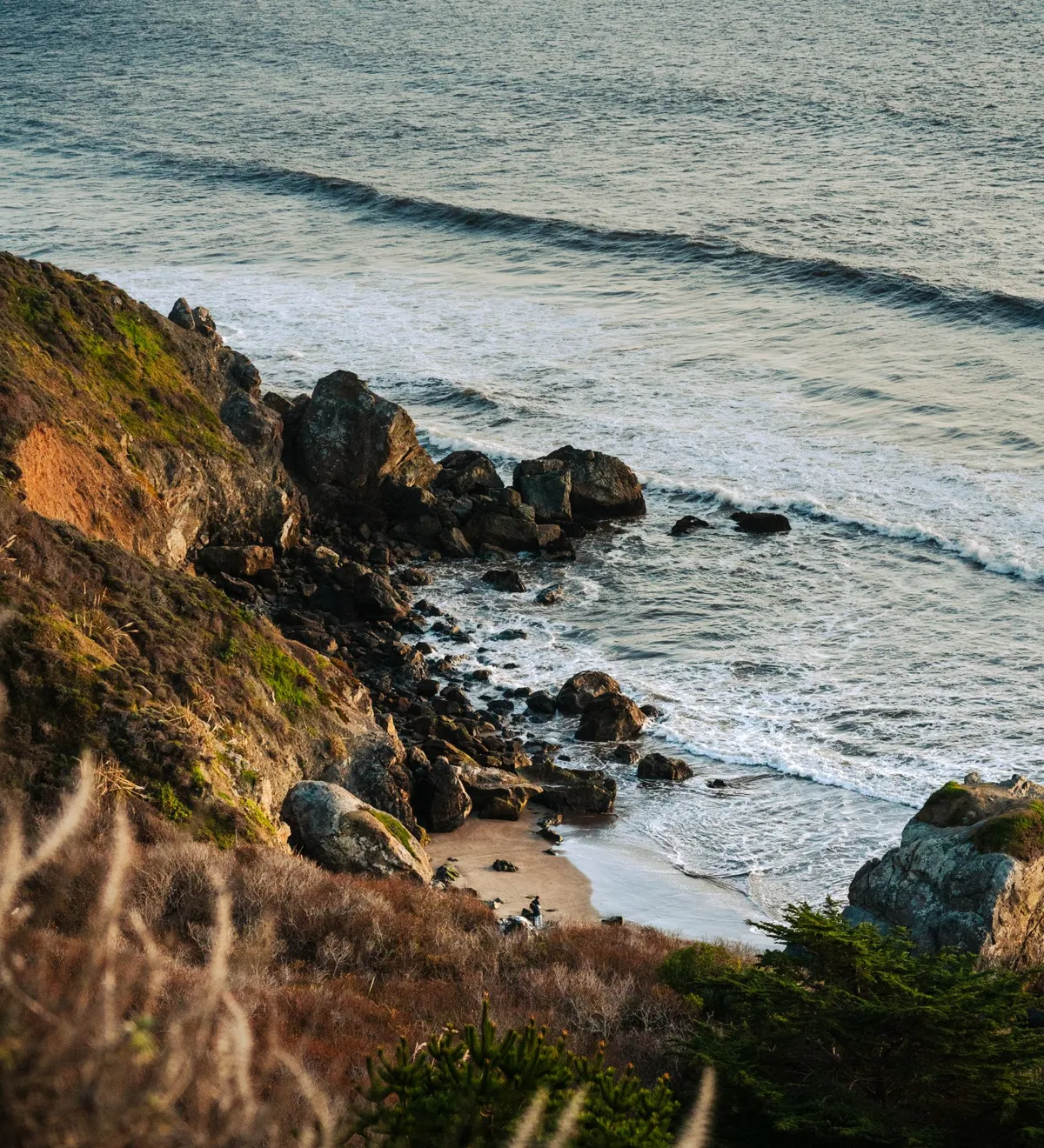 Golden evening light over a rugged coastline and Pacific waves
